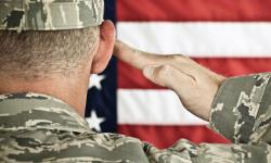 Military soldier saluting an American flag
